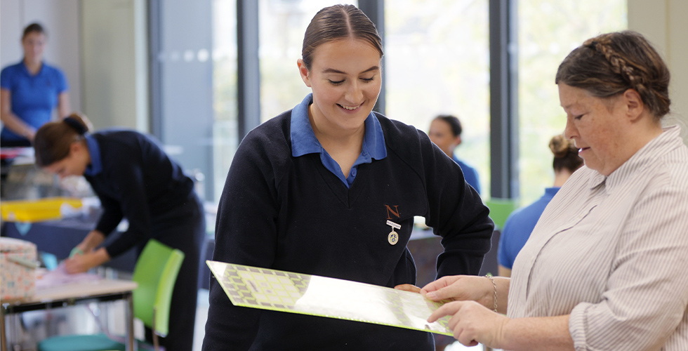 A student speaking with a Sewing Lecturer at Norland