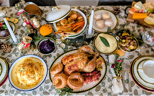 Christmas dinner on table with plates and place settings