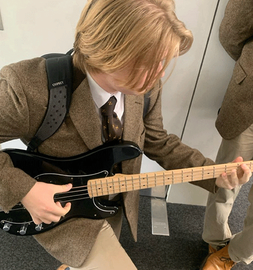 Norland student in formal uniform playing guitar