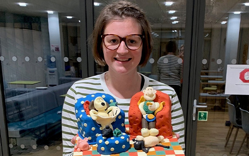 A female holding a Wallace and Gromit cake
