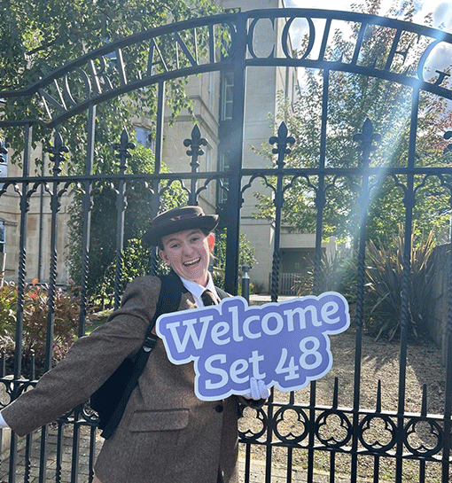 Student holding welcome sign outside of Norland gates