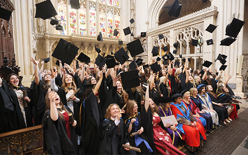 Students in graduation throwing caps into the air