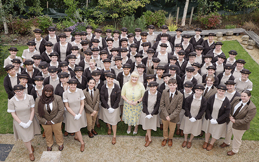 Group of Norland students in uniform smiling on campus