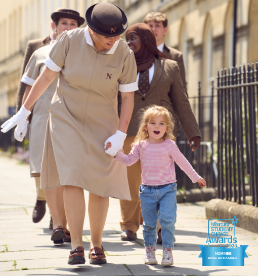 Norland students in unfirom walking with child with WhatUni nomination logo