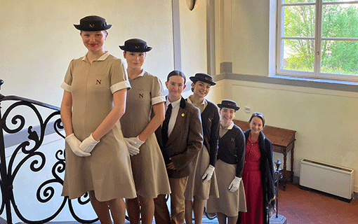Students in Pistoia in formal uniform lined up on staircase