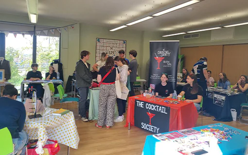 A hall at a Freshers Fair with stands of clubs and societies