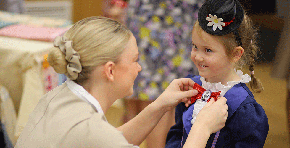 Norland student in uniform fixing a child's costume