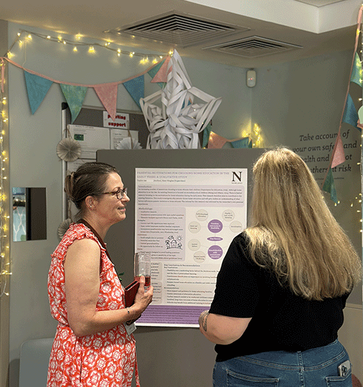 Lecturer looking at research poster from student