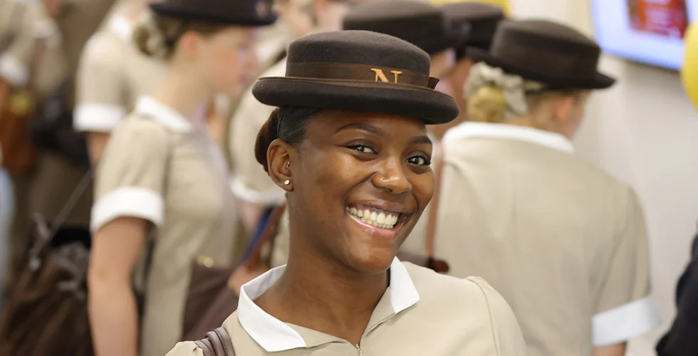 A female Norland Nanny student smiling in her formal uniform
